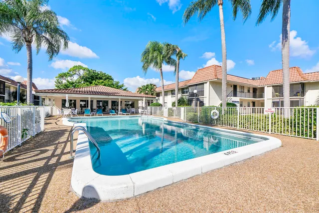 a view of a chairs and table in patio with a swimming pool