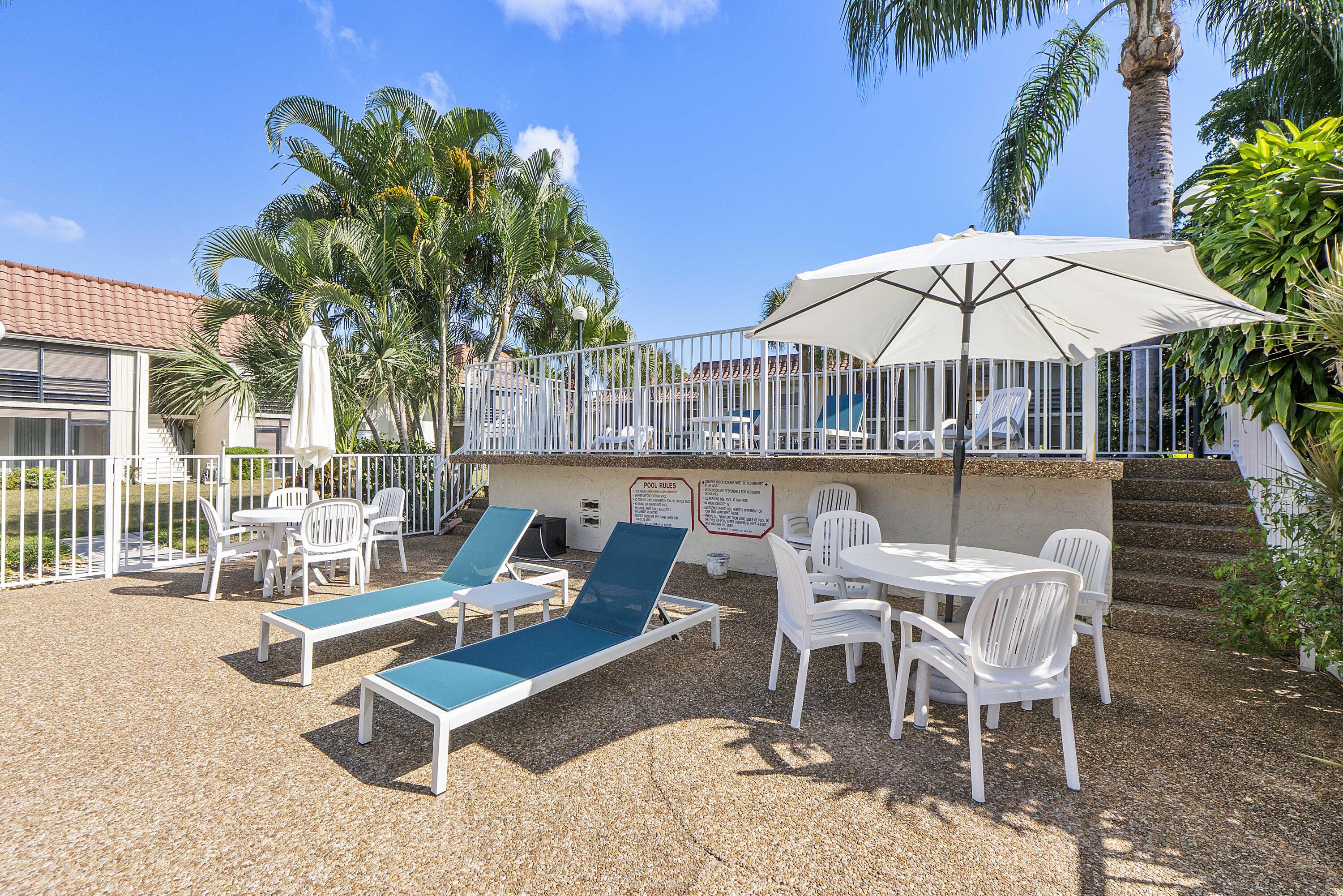 1100 Northwest 13th Street, Unit 192D Boca Raton, FL 33486 - Photo 35 of 42 a view of a chairs and table in patio with a swimming pool