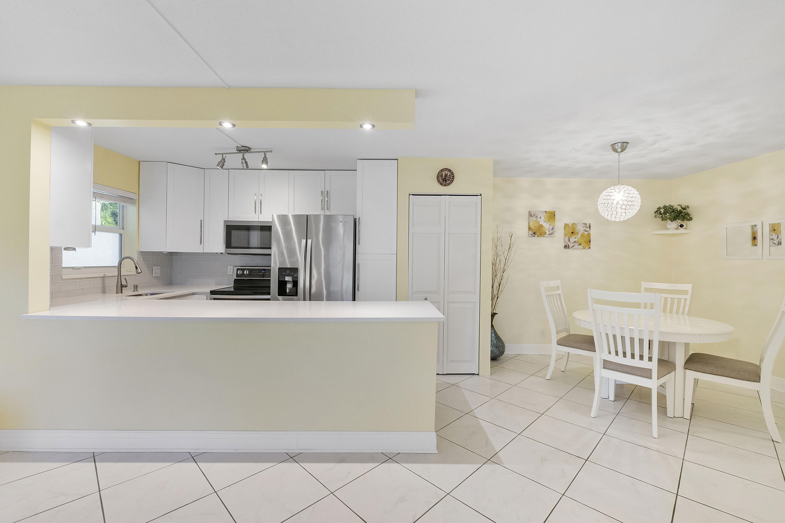 1100 Northwest 13th Street, Unit 192D Boca Raton, FL 33486 - Photo 6 of 42 a living room with furniture a dining table and a refrigerator