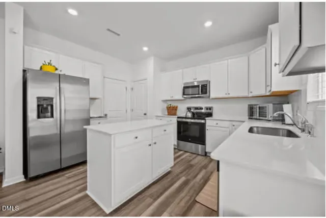 a kitchen with stainless steel appliances a refrigerator sink and microwave