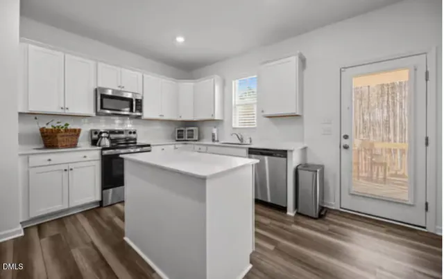 a kitchen with white cabinets and black appliances