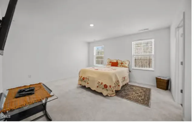 a bed sitting in a bedroom next to a window