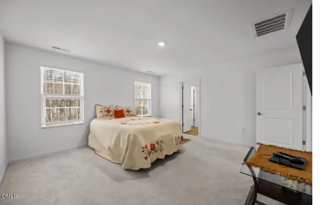 a spacious bedroom with a bed and a window