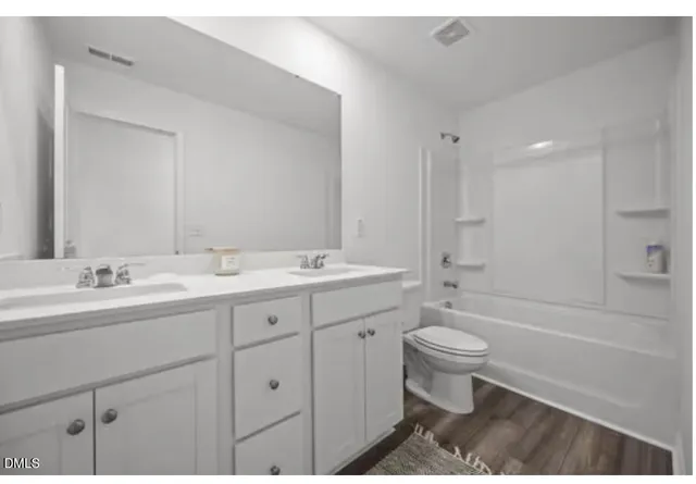 a bathroom with a double vanity sink toilet mirror and bathtub