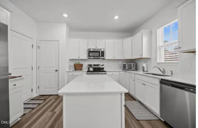 a kitchen with granite countertop a stove sink and cabinets