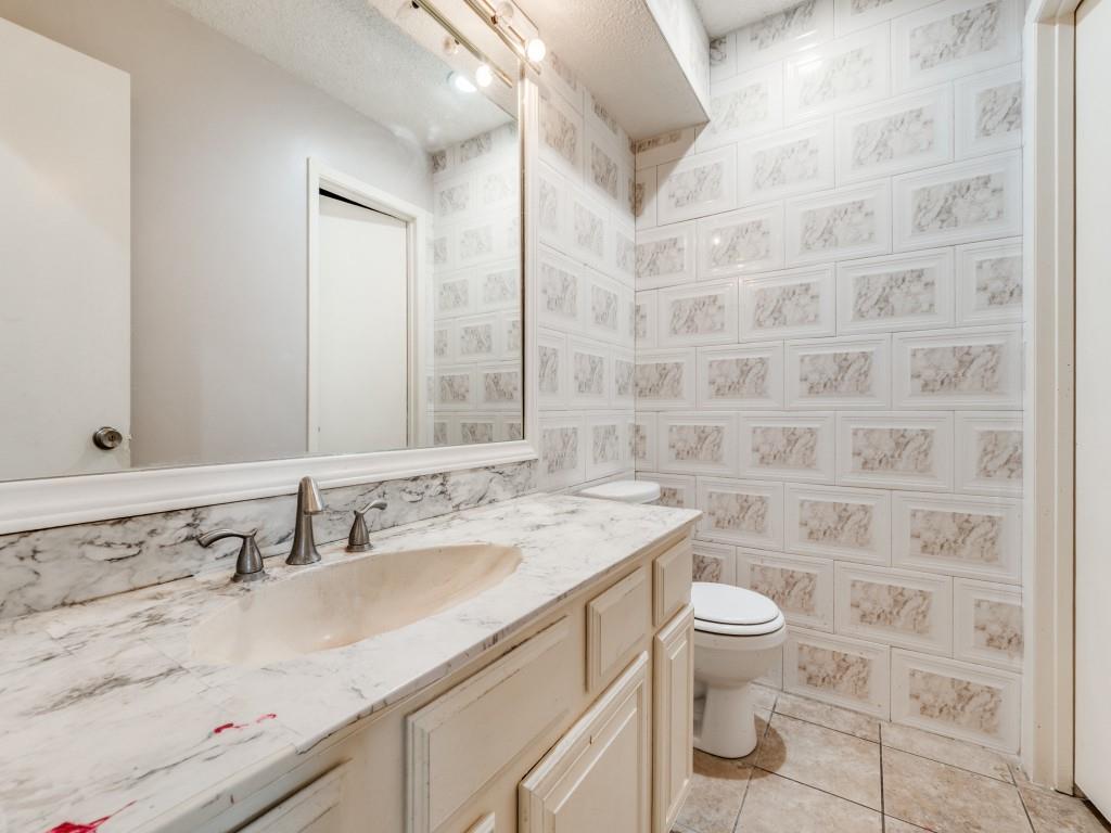 9250 Flickering Shadow Drive Dallas, TX 75243 - Photo 16 of 25 a bathroom with a granite countertop sink a toilet and a mirror