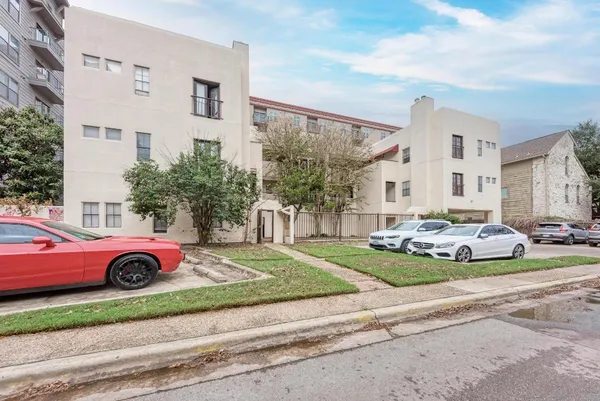 a front view of a house with a garden and parking