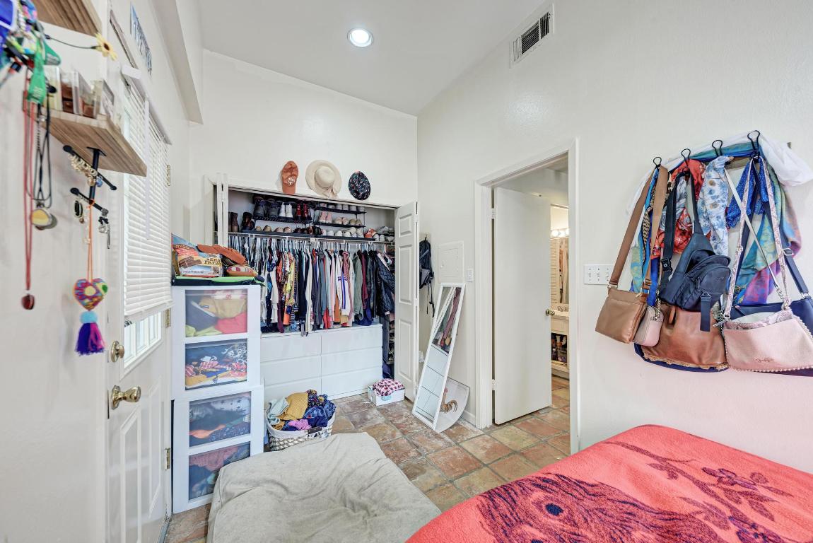 712 Graham Place, Unit 101 Austin, TX 78705 - Photo 16 of 19 Bedroom featuring a closet, stone tile floors, and recessed lighting