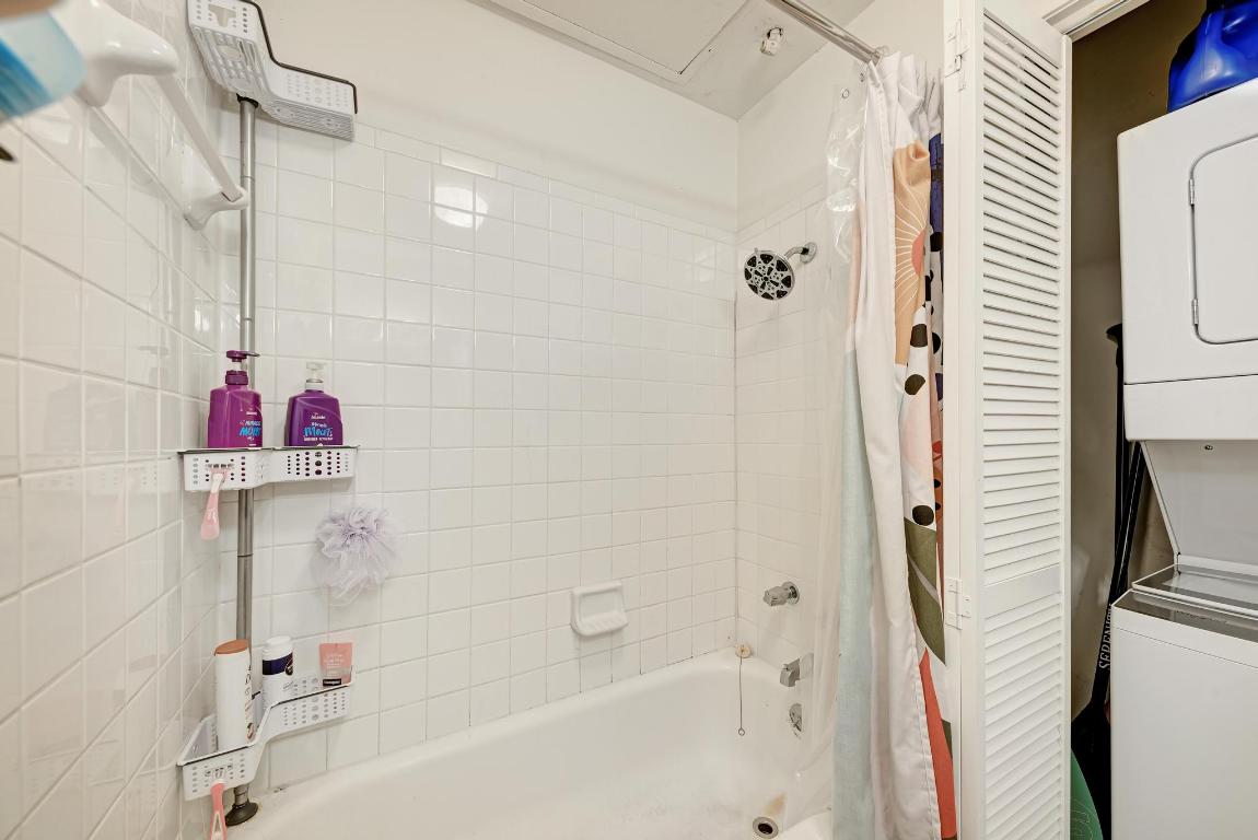 712 Graham Place, Unit 101 Austin, TX 78705 - Photo 18 of 19 Full bathroom with shower / tub combo with curtain and estacked washer and dryer