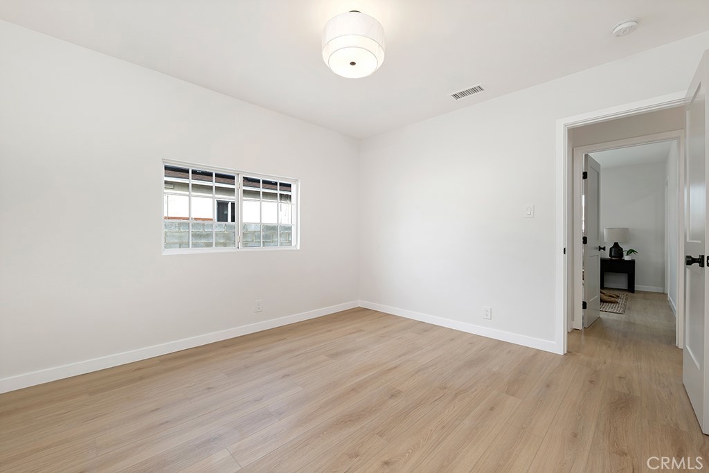 6644 Bothwell Road Reseda, CA 91335 - Photo 19 of 29 an empty room with wooden floor and windows