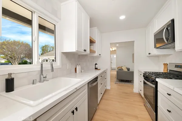 a kitchen with white cabinets and a sink