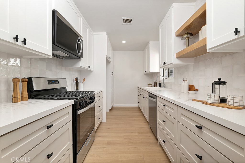 6644 Bothwell Road Reseda, CA 91335 - Photo 9 of 29 a kitchen with stainless steel appliances a sink dishwasher stove and oven with cabinets