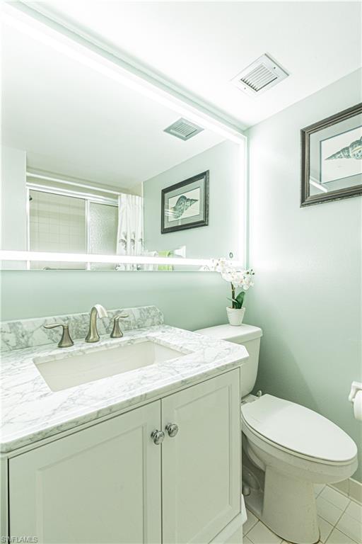 1 High Point Circle West, Unit 102 Naples, FL 34103 - Photo 17 of 35 a bathroom with a granite countertop toilet sink and mirror