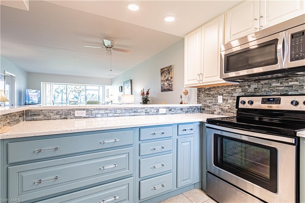1 High Point Circle West, Unit 102 Naples, FL 34103 - Photo 6 of 35 a kitchen with granite countertop cabinets stainless steel appliances and a window