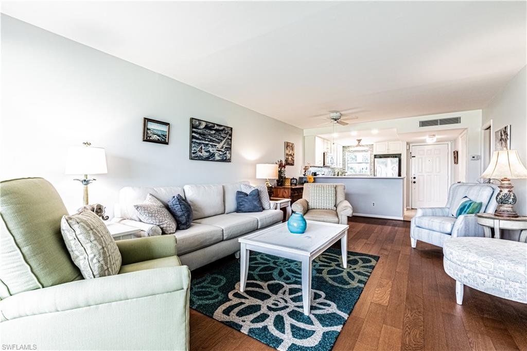 1 High Point Circle West, Unit 102 Naples, FL 34103 - Photo 7 of 35 a living room with furniture and wooden floor