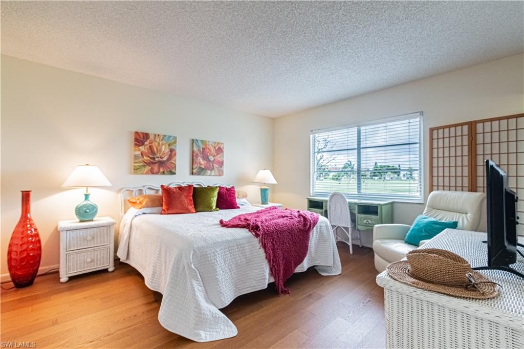 1 High Point Circle West, Unit 102 Naples, FL 34103 - Photo 9 of 35 a bedroom with a bed and a window