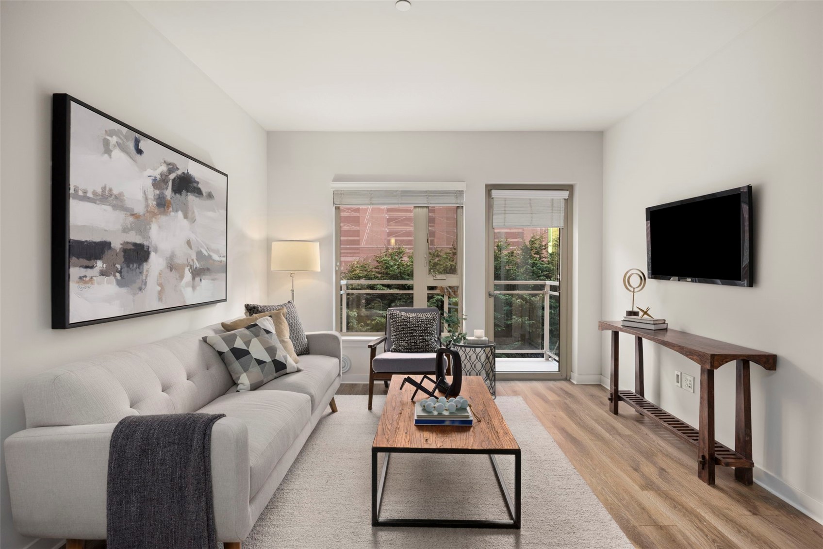1760 Northwest 56th Street, Unit 309 Seattle, WA 98107 - Photo 11 of 35 a living room with furniture a flat screen tv and a floor to ceiling window