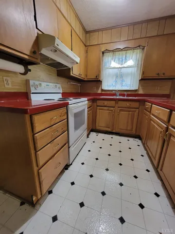 a kitchen with granite countertop a stove and cabinets