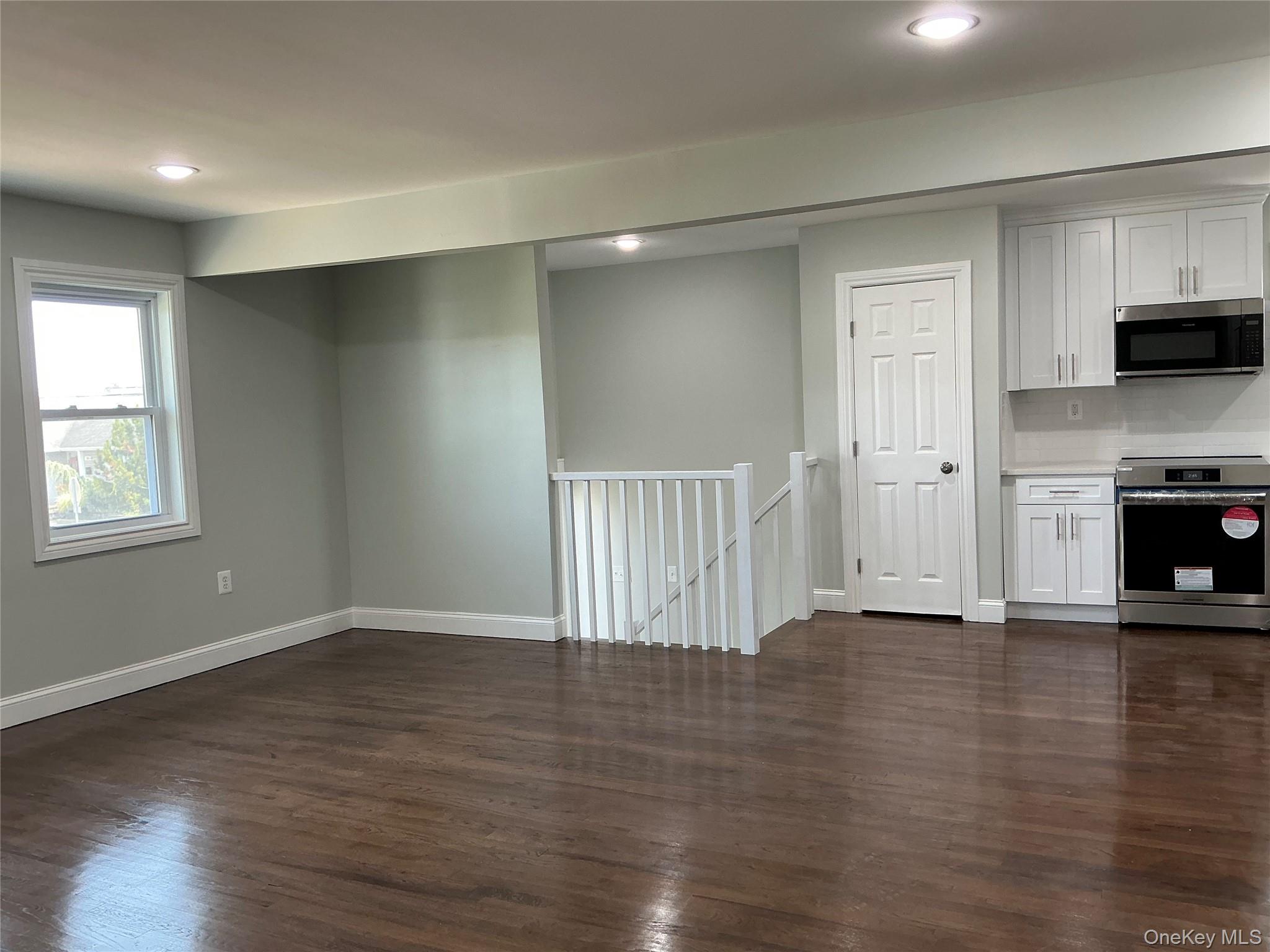 248 East Shore Road Lindenhurst, NY 11757 - Photo 16 of 46 Kitchen featuring white cabinetry, stainless steel appliances, dark wood-style floors, and recessed lighting