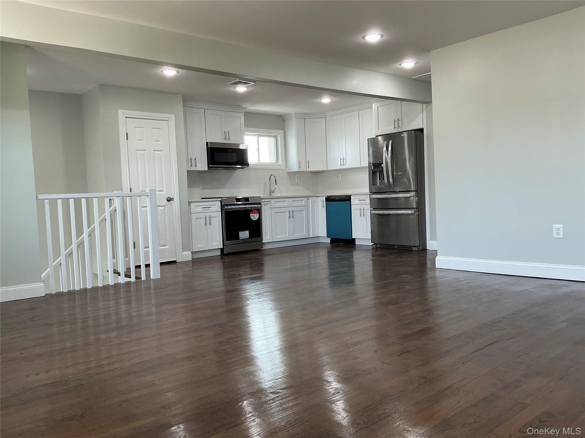 248 East Shore Road Lindenhurst, NY 11757 - Photo 19 of 46 Kitchen with white cabinets, stainless steel appliances, dark wood-style flooring, and recessed lighting