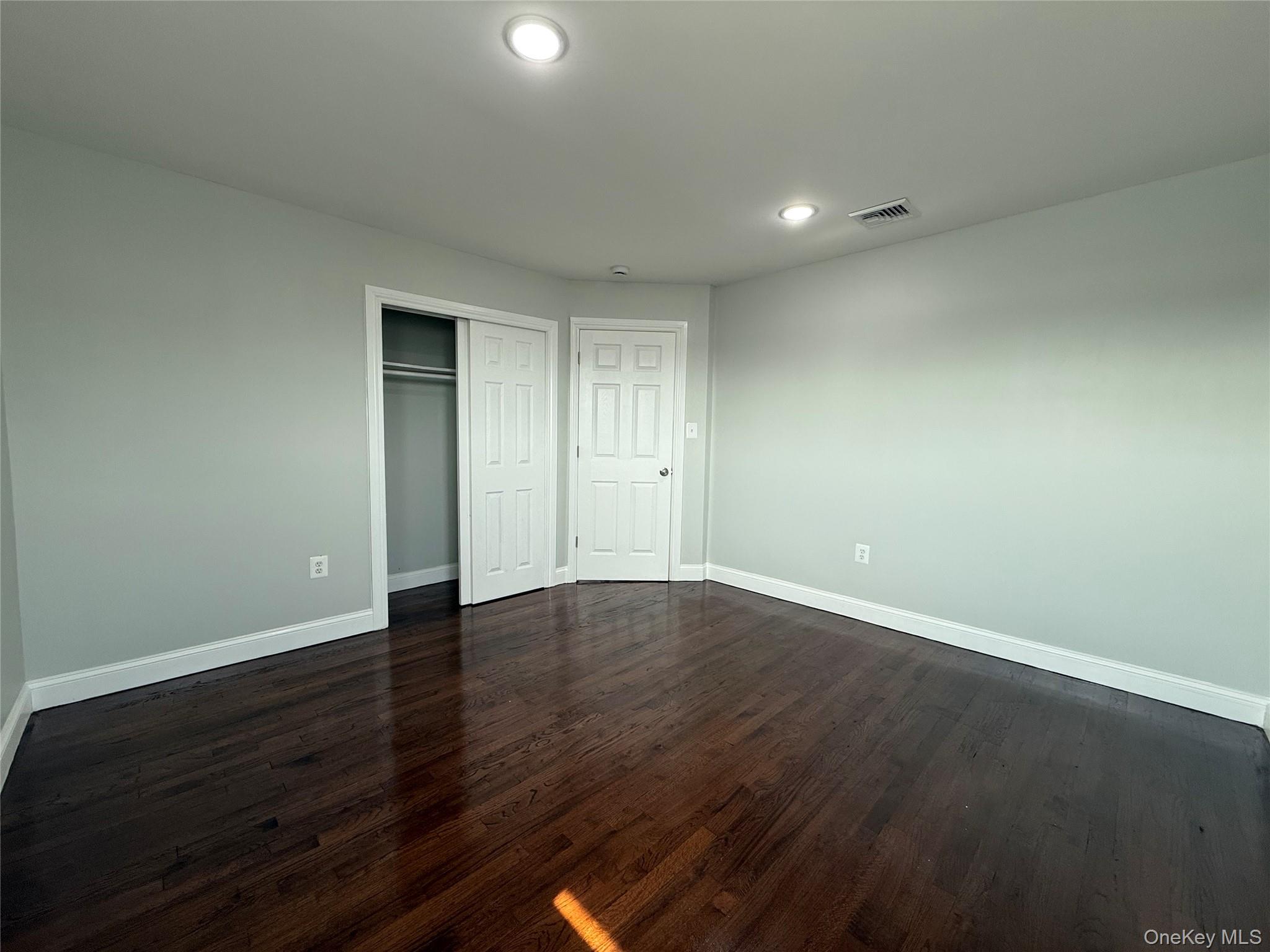 248 East Shore Road Lindenhurst, NY 11757 - Photo 28 of 46 Unfurnished bedroom with dark wood finished floors, a closet, and recessed lighting