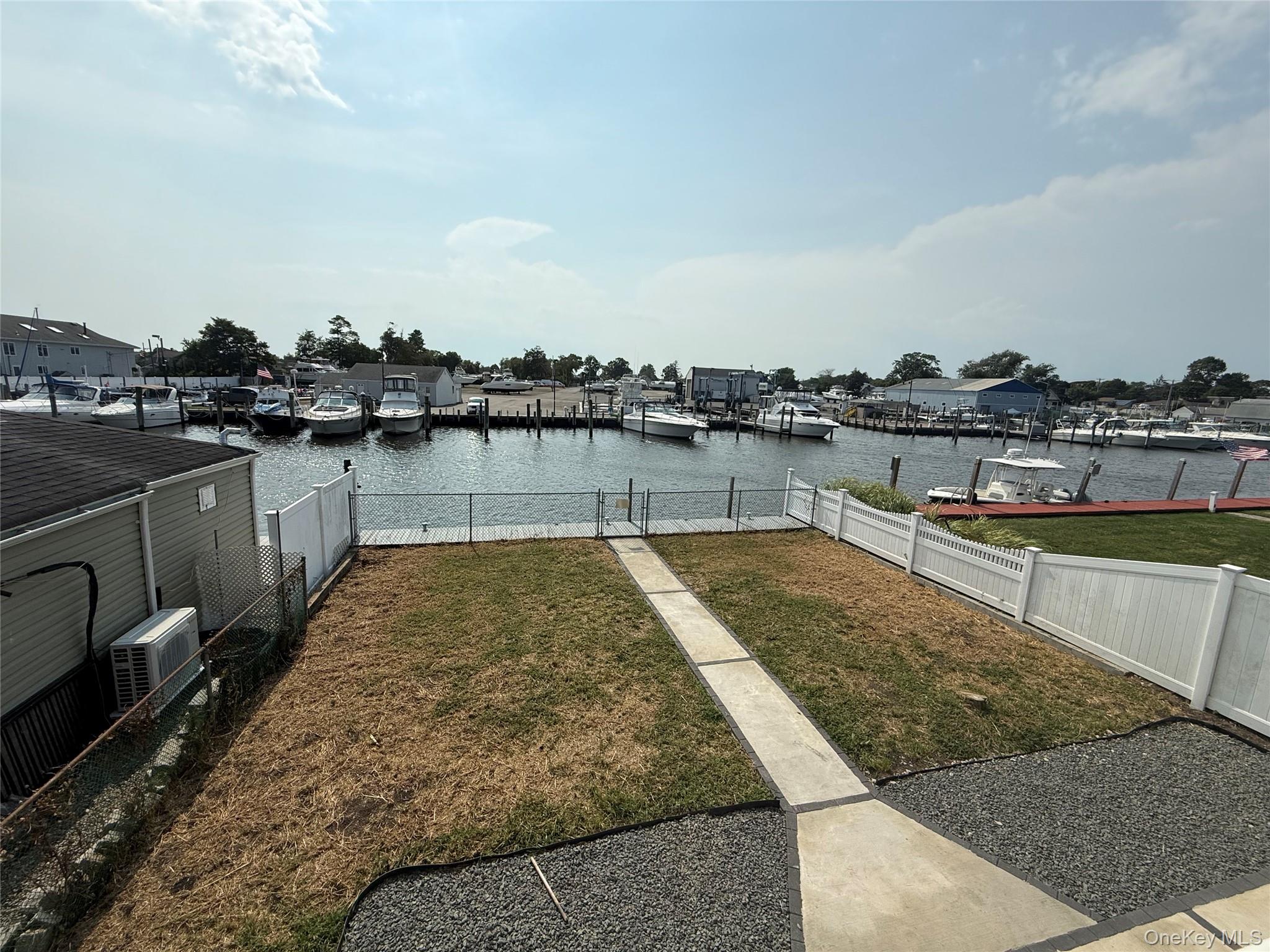 248 East Shore Road Lindenhurst, NY 11757 - Photo 32 of 46 Fenced backyard with a water view and a dock