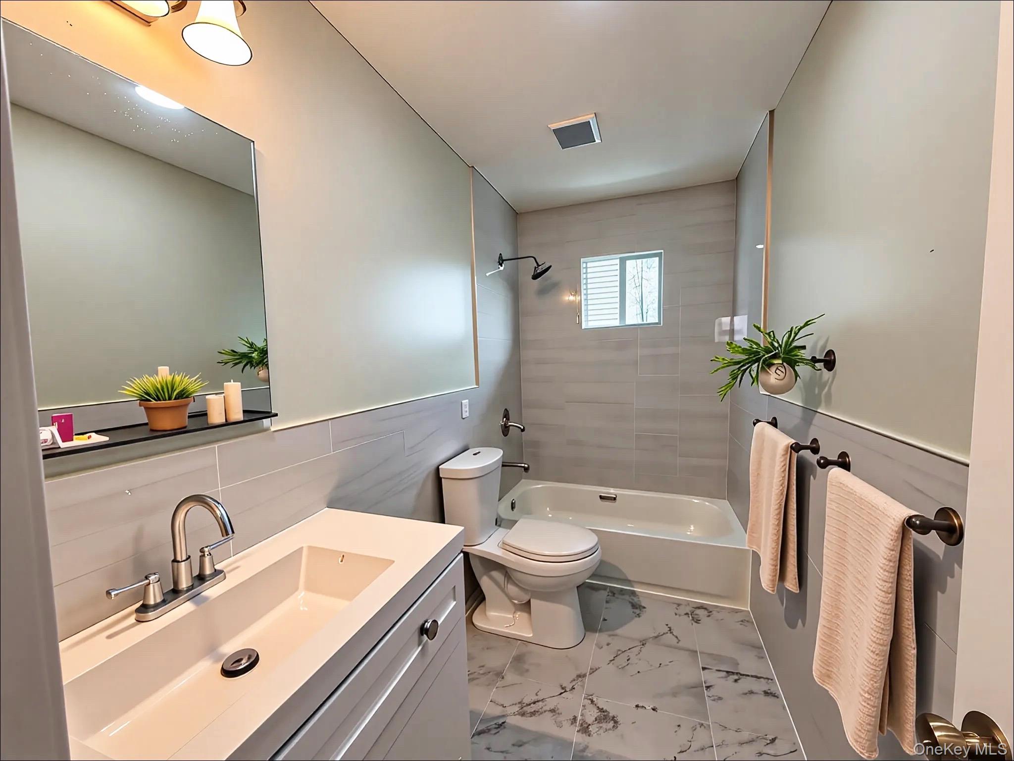 248 East Shore Road Lindenhurst, NY 11757 - Photo 9 of 46 Bathroom with washtub / shower combination, vanity, tile walls, a wainscoted wall, and light marble finish flooring