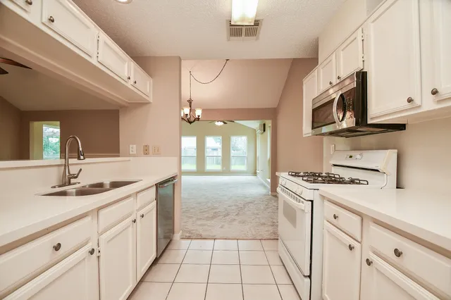 a kitchen with stainless steel appliances granite countertop a stove a sink and a microwave