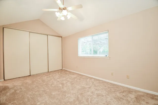 an empty room with windows and fan