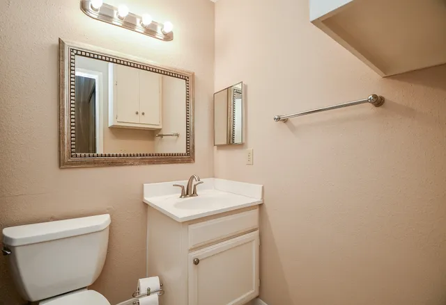 a bathroom with a toilet sink and mirror