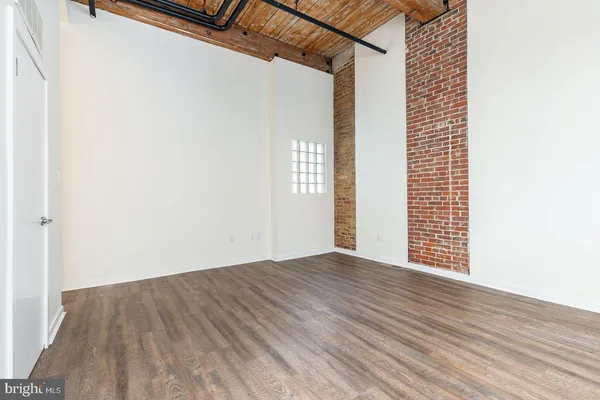 a view of a room with wooden floor and white walls