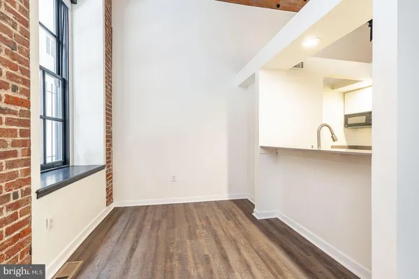 a view of empty room with wooden floor and windows