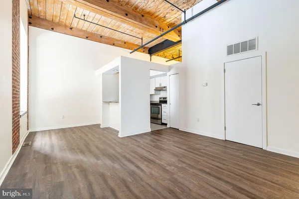 a view of empty room with wooden floor