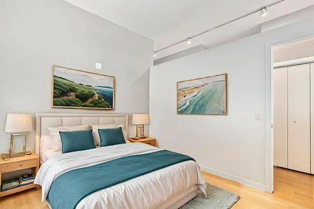 a bedroom with a bed and a painting on the wall