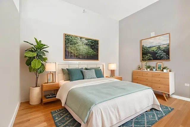 a bedroom with a bed table and a flat screen tv