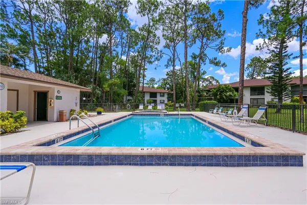 a small pool is sitting in front of a house