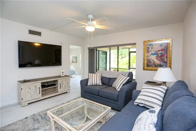 a living room with furniture and a dining table with wooden floor
