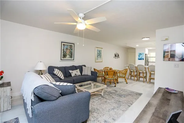 a living room with furniture and a view of kitchen