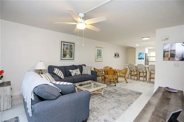 a living room with furniture and a view of kitchen