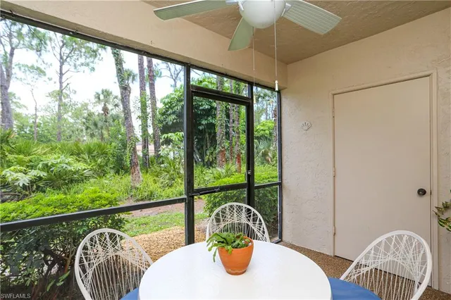a bedroom with a bed a computer on the desk and a window