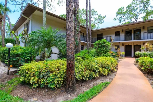 a front view of a house with a yard and potted plants