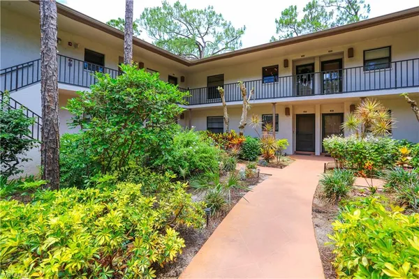 a view of a house with potted plants next to a house