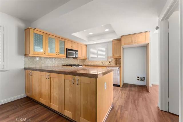 a kitchen with stainless steel appliances granite countertop a stove a sink and a microwave