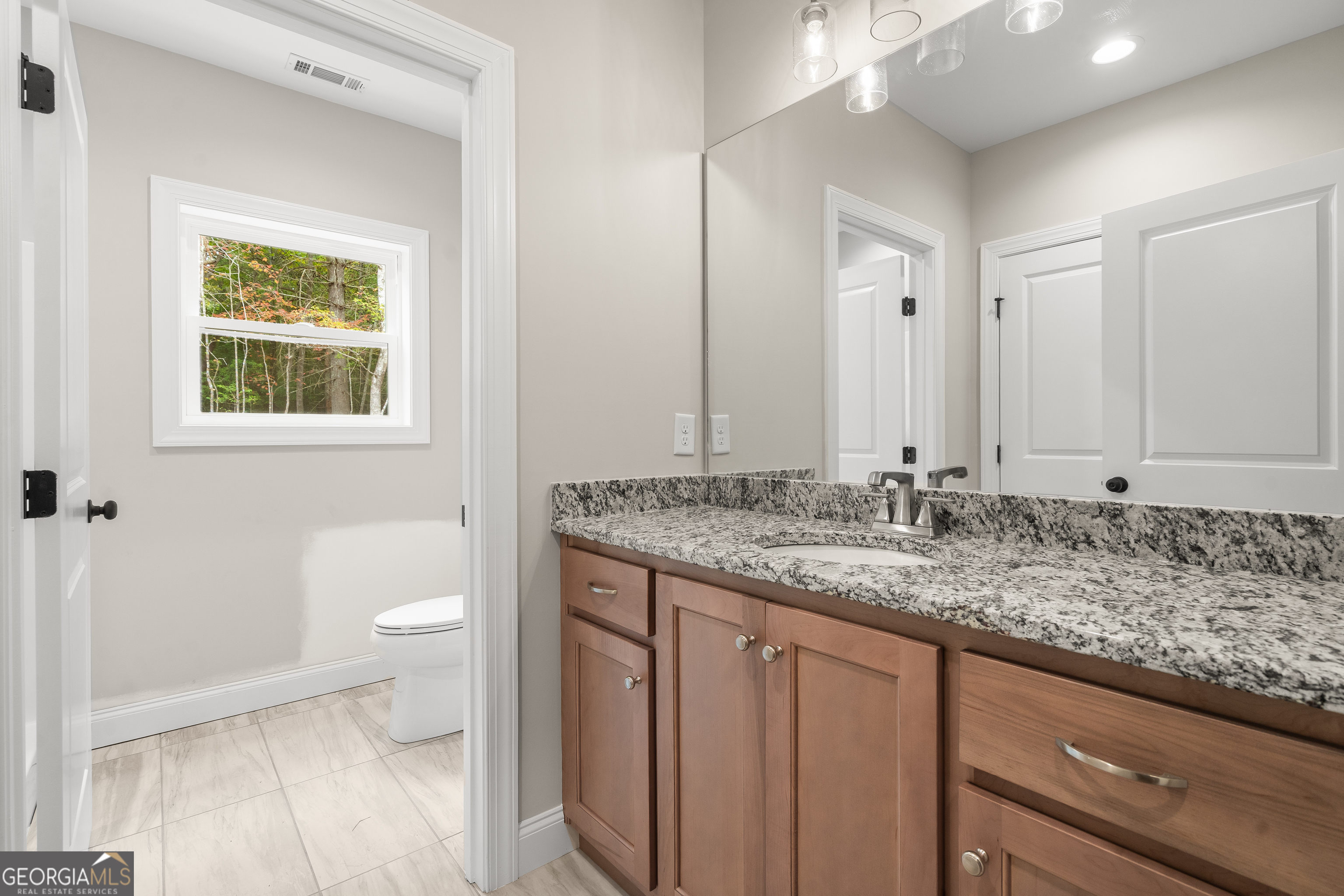 10 Hawks Nest Road, Unit 10 Blairsville, GA 30512 - Photo 31 of 32 a bathroom with a granite countertop sink a toilet and a window