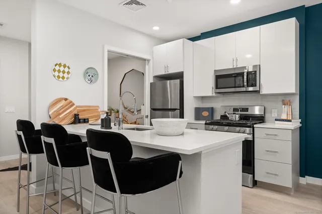 a kitchen with stainless steel appliances granite countertop a stove a sink dishwasher a microwave oven with granite countertops and cabinets