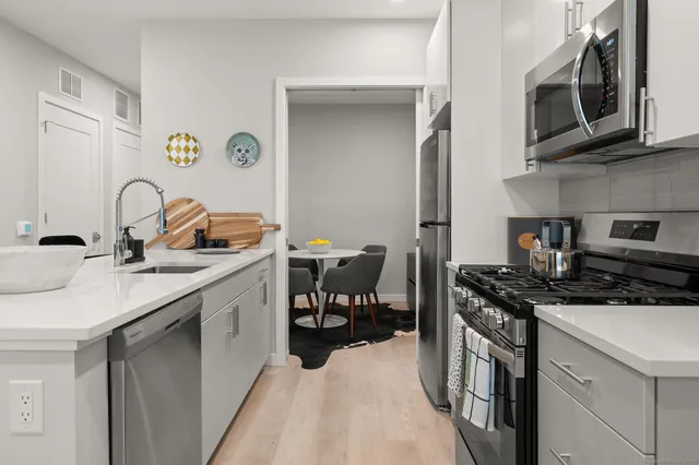 a kitchen with stainless steel appliances granite countertop a sink stove and cabinets