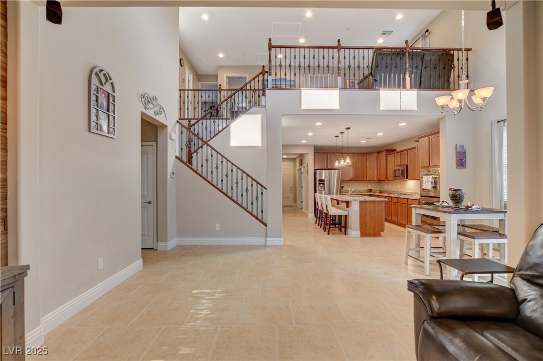 5741 Shadow Bend Drive Las Vegas, NV 89135 - Photo 25 of 78 Living room featuring baseboards, stairway, a high