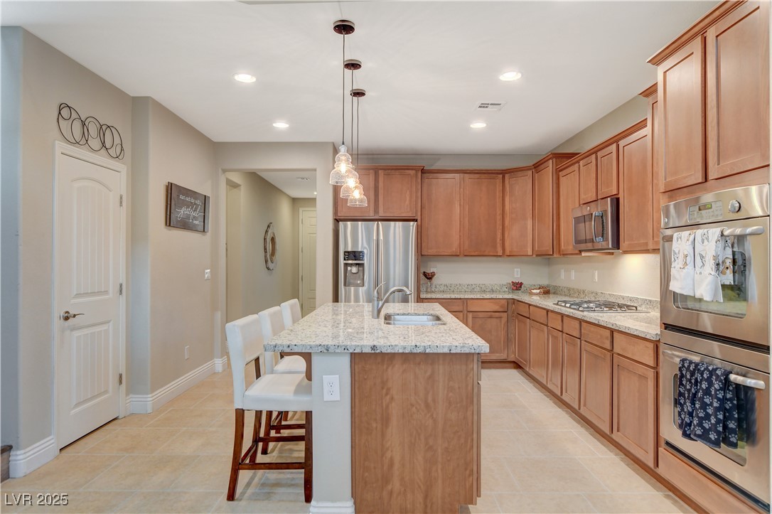 5741 Shadow Bend Drive Las Vegas, NV 89135 - Photo 10 of 78 Kitchen featuring a kitchen island with sink, stai