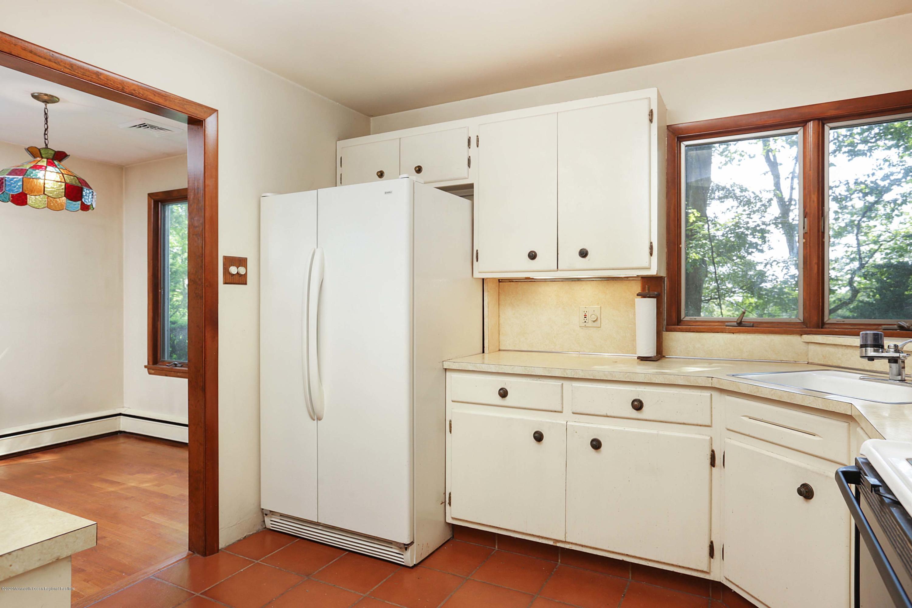17 Lawrie Road Atlantic Highlands, NJ 07716 - Photo 7 of 32 a kitchen with granite countertop white cabinets and white appliances
