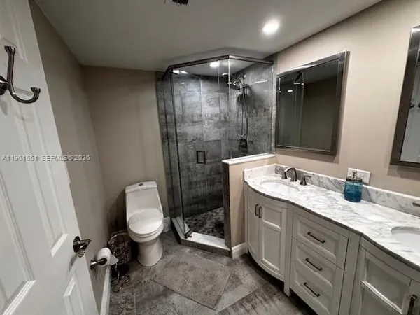 a bathroom with a granite countertop sink toilet and shower